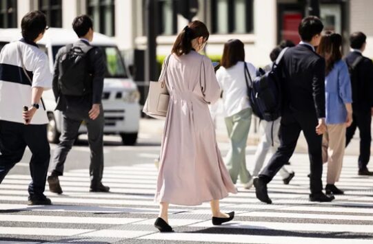 横断歩道を一人歩くピンクワンピースの日本人女性の後ろ姿 ─ Mani Padme 40代女性の人生転換期・群衆の中の孤独と本当の自分を取り戻すブログ