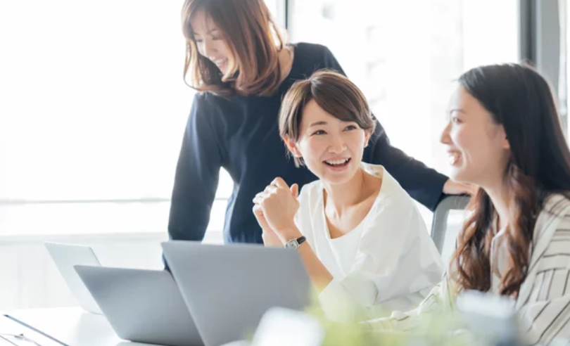 パソコン画面を囲み笑顔で喜ぶ三人の日本人女性 ─ Mani Padme40代・なりわいと仲間と共に達成する仕事の喜び